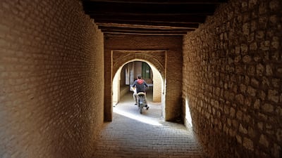 A boy rides a bicycle in a residential area of Nefta.