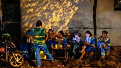 Workers sit on stools along a street in Hanoi, Vietnam. Bloomberg