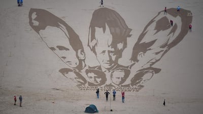 Activists put the finishing touches to a sand drawing of the G7 leaders, calling on them to 'share the vaccine' on Watergate Bay beach near Newquay, Cornwall ahead of the three-day G7 summit. AFP