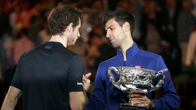 Serbia's Novak Djokovic, right, shakes hands with Britain's Andy Murray while holding the men's singles trophy after winning their final match at the Australian Open tennis tournament at Melbourne Park, Australia, January 31, 2016. REUTERS/Thomas Peter