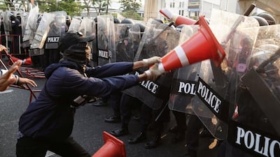 Anti-Thai government protester wields a traffic cone at riot police during a clash at a rally for Myanmar's democracy outside the embassy, in Bangkok, Thailand. Reuters