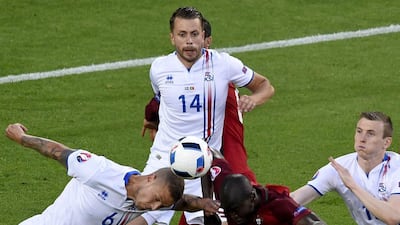 Iceland’s defender Ragnar Sigurdsson (L) vies for the ball against Portugal’s midfielder Danilo Pereira (C) as Iceland’s defender Kari Arnason (C top) looks on during the Euro 2016 group F football match between Portugal and Iceland at the Geoffroy-Guichard stadium in Saint-Etienne on June 14, 2016. Jean-Philippe Ksiazek / AFP