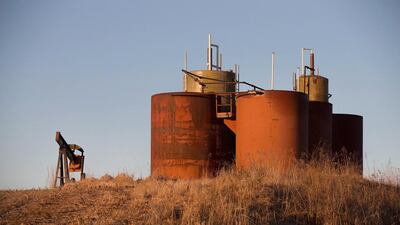 An idled pump jack, once used to extract crude oil from the ground, and a tank battery, used to temporarily store the freshly-pumped crude, rust away in a farmer’s field near Ridgway, Illinois. Scott Olson / Getty Images / AFP