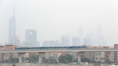 Dubai Metro passes down the Expo 2020 route underneath hazy skies in Dubai. Pawan Singh / The National
