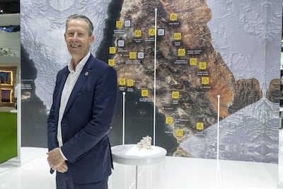 Andrew McEvoy at Arabian Travel Market with a map of Saudi Arabia's planned super-city Neom. The National