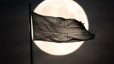 A Union flag flutters in sight of the near full moon in Whitehall in London, England. Peter Macdiarmid / Getty