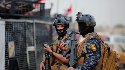Members of Iraqi federal police are seen with military vehicles in a street in Baghdad, Iraq. REUTERS