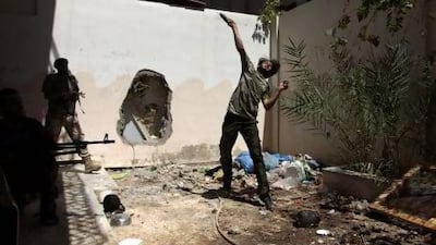 A Free Syrian Army fighter throws a homemade bomb towards forces loyal to Syria's President Bashar Al Assad as fellow fighters watch in Deir Al Zor