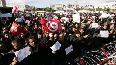 Tunisians, among them policemen, gather to ask for the right to form unions and better salaries as the vehicle of Tunisia's interim president, Fouad Mbazaa, arrives at the government palace in Tunis.