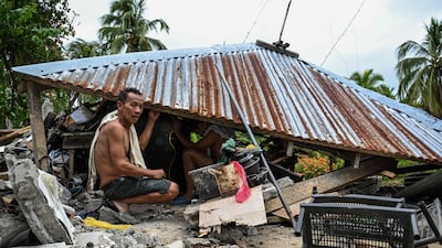 Searching the ruins of a collapsed house in Manay, in the province of Davao Oriental, after two powerful earthquakes struck off the southern Philippines, killing at least eight people and leading to tsunami warnings. AFP