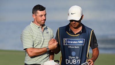 Rory McIlroy of Northern Ireland walks off the 18th hole with his caddie at Emirates Golf Club. Getty