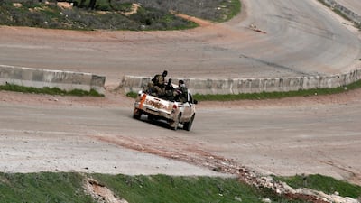 Fighters drive through Idlib city center from Saraqeb in Idlib province, Syria. REUTERS